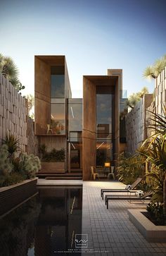 an outdoor swimming pool surrounded by palm trees and other greenery in front of a house