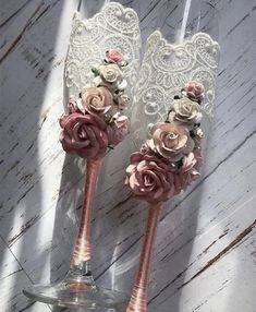 two wine glasses decorated with pink roses and lace