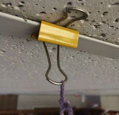 a yellow object hanging from the ceiling in a room with white walls and carpeting