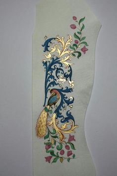 an intricately designed piece of paper with flowers and leaves on it, hanging from the wall