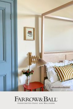 a bedroom with a canopy bed next to a red table and blue door in the background