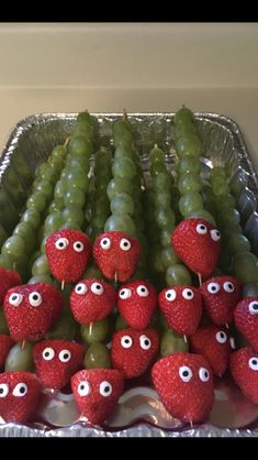 some grapes and strawberries with eyes on them