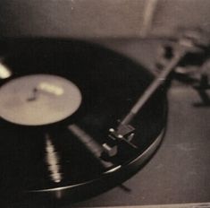 an old record player with its turntable and tape recorder in the foreground, black and white photograph