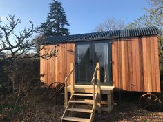 a small wooden cabin with stairs leading to it