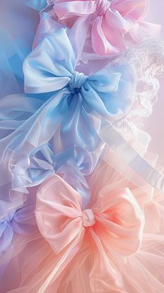 three different colored bows on top of each other in front of a blue and pink background