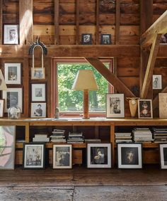 a room filled with lots of framed photos and pictures on the wall next to a window