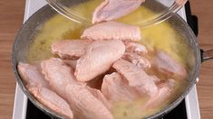 chicken being cooked in a pan on top of an electric burner with yellow liquid