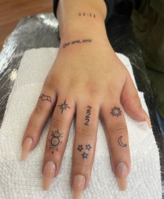 a woman's hand with tattoos on it and the word sun, moon and stars