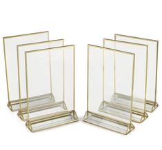 three clear and gold glass vases sitting next to each other