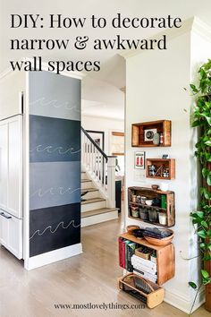 a living room filled with furniture next to a stair case and wall mounted bookshelf