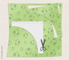 scissors and paper cut out to look like soccer balls on green fabric with white background