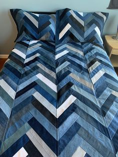 a bed with blue and white chevroned bedspread on top of it