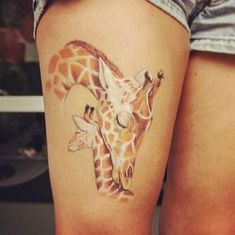 a giraffe tattoo on the leg of a woman