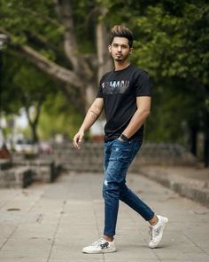 a young man is walking down the street with his foot in the air and wearing white sneakers