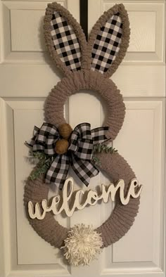 a welcome sign is hanging on the front door with a bunny ears and plaid bow