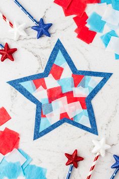 red, white and blue paper stars on a marble surface with candy canes in the foreground