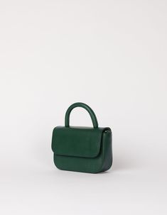 Our ever-popular mini bag, the Nano in a classic autumnal hue: Pine Green, for our FW24 collection. One of the smallest and most compact bags in our collection: The Nano Bag. This itty-bitty bag is all about the essentials. With enough space for your mobile phone, coin purse, lip balm and keys, the little Nano Bag makes a big statement. Featuring an inside zip pocket for extra security and a slip-in pocket for easy access. Her front flap closes with an inner magnet and her strap has a knob-button system to adjust the length. OMB-E137PGV Compact Bag, Weekender Tote Bag, Bags Logo, Pine Green, Boot Bag, Work Bags, Mini Crossbody Bag, Itty Bitty, Toiletry Bags