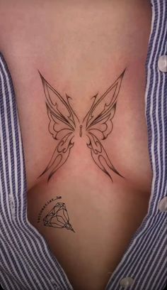 a woman's chest with a butterfly tattoo on her left side ribcage