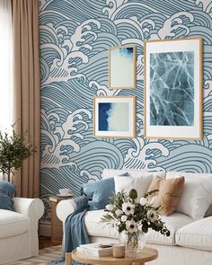 a living room with blue and white wallpaper, two couches and a coffee table