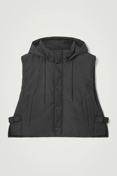 This season, we've created a mini capsule of hybrid pieces that are designed to be worn in a multitude of ways. Part of the edit, this padded vest is crafted from 100% recycled polyester and has practical features in abundance – note the drawstring hood, welt pockets and adjustable buckled tabs at the side. Layer it under a coat for extra warmth.  Regular fitZip closureA better alternative to conventional polyester, recycled polyester is made from pre‐ and post‐consumer waste Shell & Lining: 100% Recycled polyester / Machine wash Back length of size XS/S is 21.37", M/L: 21.96" Hooded Nylon Vest For Streetwear, Functional Hooded Nylon Vest, Functional Vest For Streetwear, Functional Streetwear Vest, Functional Nylon Puffer Jacket, Functional Nylon Vest Outerwear, Functional Nylon Puffer Jacket For Streetwear, Functional Hooded Outdoor Vest, Hooded Nylon Vest For Outdoor Activities