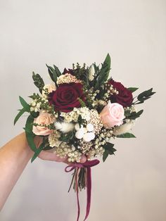 someone holding a bouquet of flowers in their hand