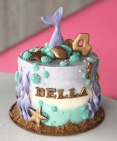 a birthday cake decorated with mermaid decorations