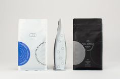 two different types of coffee bags next to each other on a white surface with a black and blue design