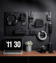 a laptop computer sitting on top of a wooden desk next to a wall mounted camera