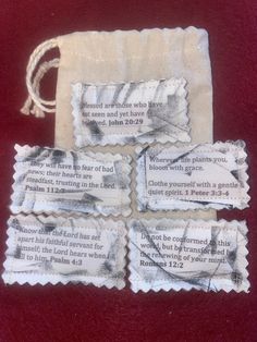 four pieces of paper with words on them sitting on a red tablecloth covered surface