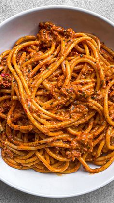 a white bowl filled with spaghetti and sauce