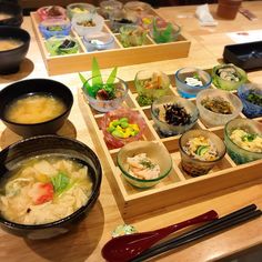 several bowls of food on a table with chopsticks