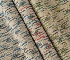 three different colors of fabric, one with multicolored stripes and the other beige