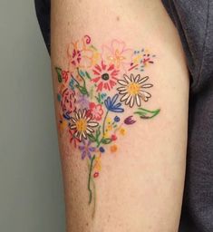 a woman's arm with flowers painted on it