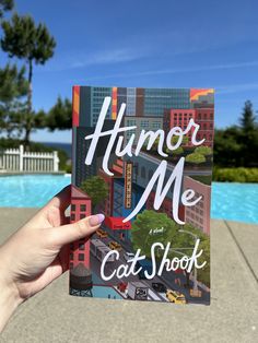 a person holding up a book with the title humor me cat shock written on it