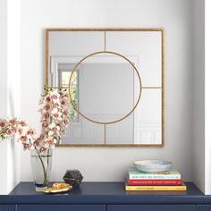 a blue dresser with flowers and a mirror on it's sideboard in a white room