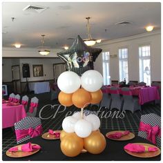 there are balloons and plates on the table in this room with black tables cloths