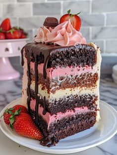 a piece of chocolate cake with pink and white frosting on a plate next to strawberries