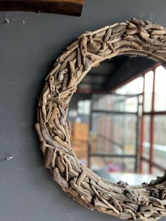 a mirror made out of driftwood is hanging on the wall