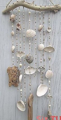 a wall hanging with shells and seashells attached to it's sides on a wooden surface