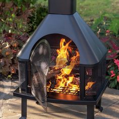 an outdoor fire pit is shown with flames coming out of the front and side sides