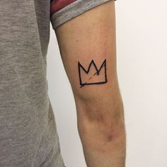 a man's arm with a crown tattoo on the left side of his arm