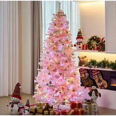 a pink christmas tree with presents under it