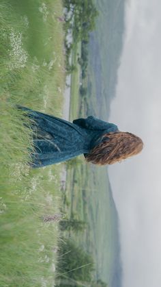 a woman standing on top of a lush green field