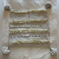 a piece of cloth with fringes and beads hanging from it's sides on a bed