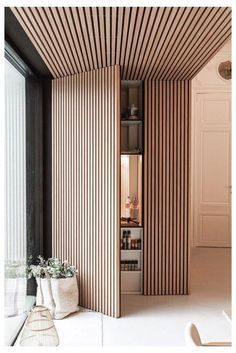 the interior of a room with vertical striped walls and wooden slats on the ceiling