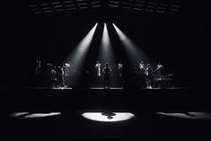 a group of people standing on top of a stage in the middle of a dark room