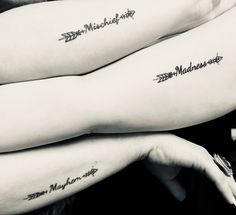 two women with matching tattoos on their arms are holding onto each other's arm