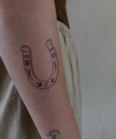 a tattoo on the arm of a person with a horse shoe in it's middle