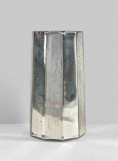 a silver vase sitting on top of a white table