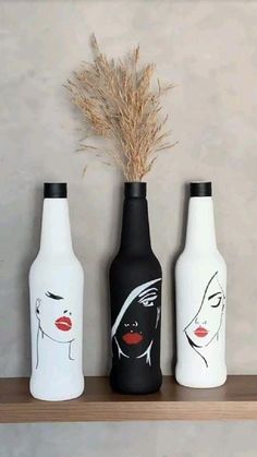 three black and white vases sitting on top of a shelf